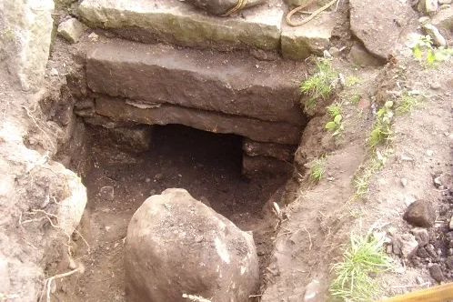 The stone-lined entrance to a mine shaft uncovered during excavation at Bannockburn House. The heavy lintel and carefully constructed opening point to a date possibly as early as the 16th century.